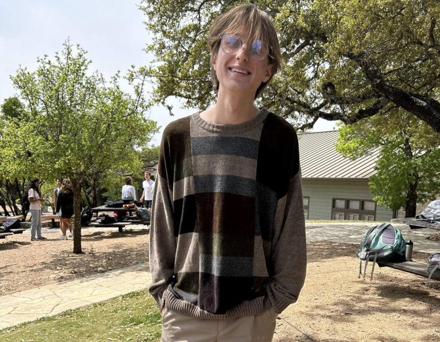 Jacob McDaniel (12th grade) dresses like the talented ceramist he is. His outfit, especially his sweater, uses an earthy color palette. This statement piece molds the color palette into a pattern of overlapping rectangles, which is simple yet eye catching. Meanwhile, the striped lining of the sweater adds to the relaxed vibe of the outfit.